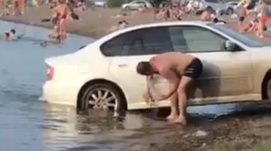 Мужик загнал машину на пляж и стал ее мыть (Видео)